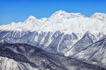Fototapeta premium Beautiful snowy mountain peaks and blue sky scenic winter landscape of the Main Caucasian ridge
