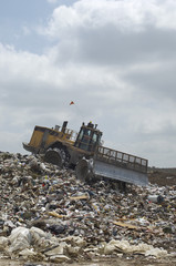 Excavator moving trash at a landfill