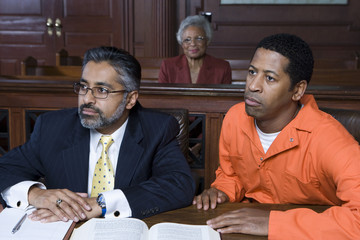 Lawyer and accused criminal sitting in the courtroom