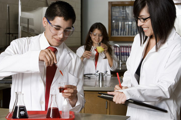 Professor examining high school students in science laboratory