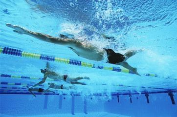 Four swimmers swimming together in a line during race