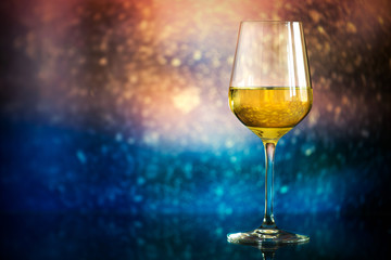 glass of white wine against a glowing bokeh - copy space, select