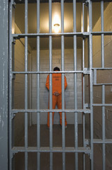 Criminal standing behind prison bars