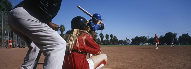 Professional female baseball team practicing on ground with umpire