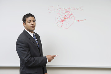 Male African American professor teaching on whiteboard