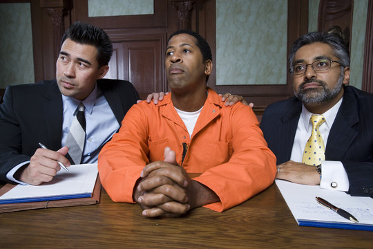 Two lawyers with criminal sitting in the courtroom