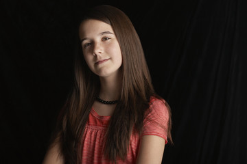 Closeup portrait of beautiful teenage girl isolated on black background