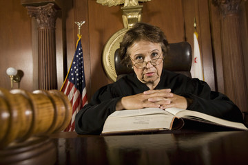 Portrait of female judge with law book in the courtroom