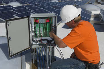 Electrical engineer repairing electricity box at solar power plant