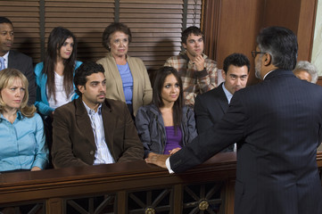 Male attorney addressing jury in courthouse