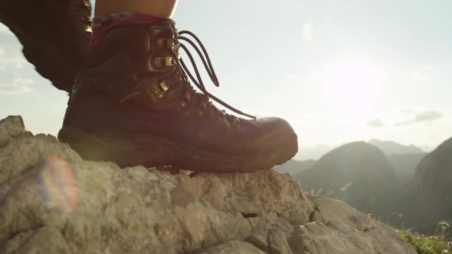 CLOSE UP: Detail of female hiking boots and hiking downhill on rough terrain