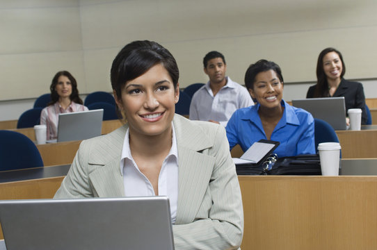 Happy businesswoman in presentation with business colleagues sitting in the background