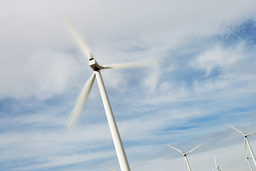 Wind turbines against cloudy sky