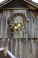 Giant Wedding Wreath with Beautiful Flowers on the side of a Rustic Barn