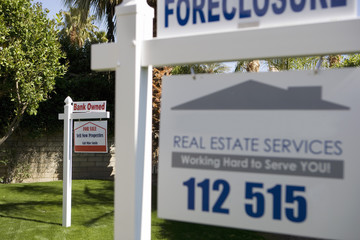 Closeup of real estate signs at foreclosed property