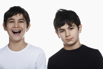 Obraz premium Closeup portrait of confident preadolescent boy with happy brother isolated over white background