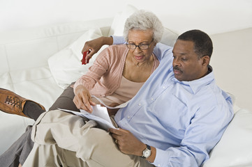 Tensed African American couple looking at bills worried with home finances - Powered by Adobe