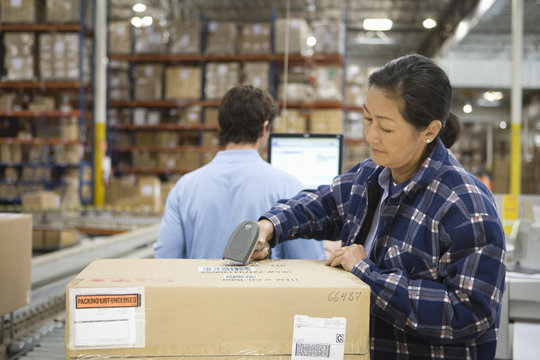 Woman And Man Working In Distribution Warehouse