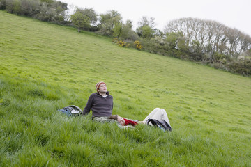 Young hiking couple relaxing on grass