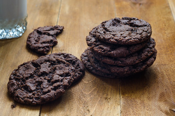 Photo of freshly baked chocolate chips cookies on wooden board