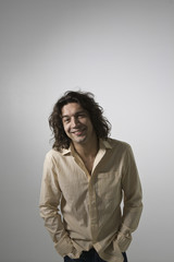 Fototapeta premium Smiling young man standing against gray background