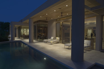 View of luxury house exterior with swimming pool at night