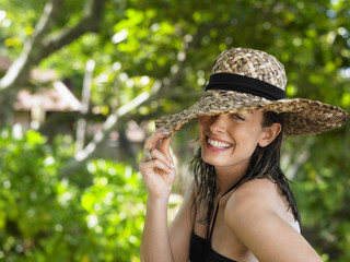 Closeup portrait of a smiling young woman with sun hat