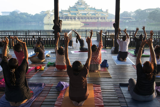 Morning exercices in Kandogyi park with Karaweik hall in background, Yangon (Rangoon)