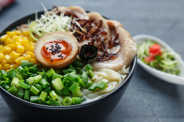tonkotsu ramen, japanese noodle soup with pork belly, corn, spring onion and nitamago on top