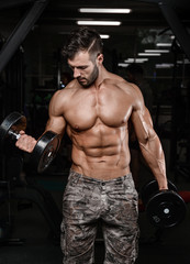 Naklejka na ściany i meble Strong and handsome athletic young man muscles abs and biceps.