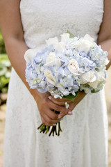 Bride Holding Bouquet of White Roses and Blue Hydrangea