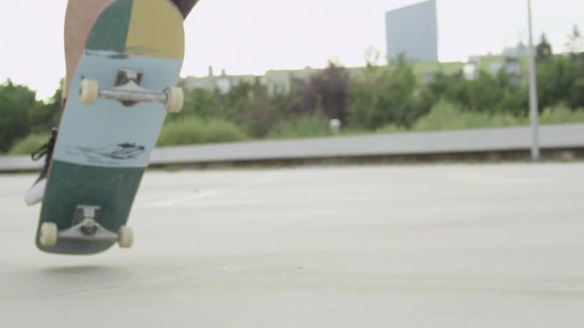 SLOW MOTION CLOSE UP: Skateboarder jumping flip trick and falling down on street