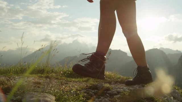 CLOSE UP: Detail of leather mountain shoes and female climbing steep mountaintop