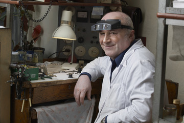 Portrait of smiling senior watch repairman in workshop