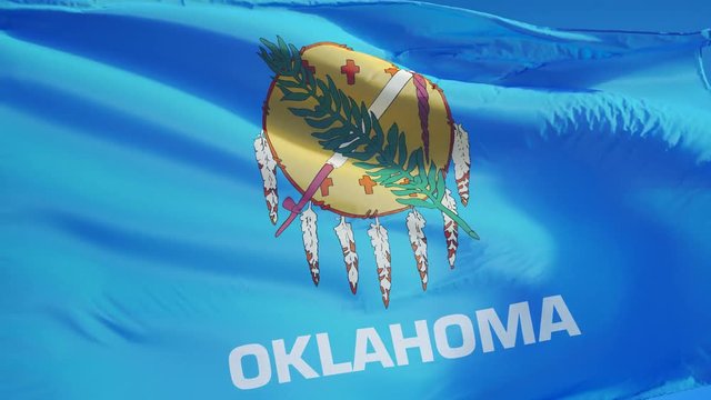 Oklahoma (U.S. state) flag waving in slow motion against blue sky, seamlessly looped, close up, isolated on alpha channel with black and white matte, perfect for film, news, composition