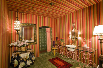 Illuminated bathroom with lit lights by mirror and washbasin in home