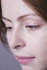 Fototapeta premium Detail shot of a pensive young woman against colored background