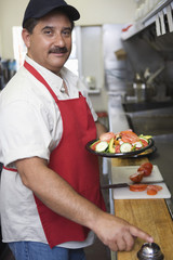 Portrait of Hispanic Latin man ringing bell with food ready to serve