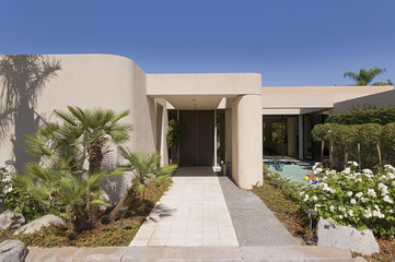 Fototapeta premium Lawn and walkway in front of a modern house against clear sky
