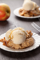 Large dish of apple crisp with vanilla ice cream on top