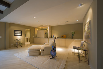 Guitar by reclining chair in a spacious room at home