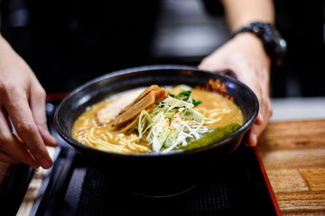 Cook geeting ready the Ramen for serving