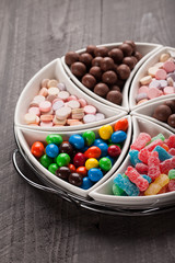 Macro shot of large container with separated assortments of colorful candy