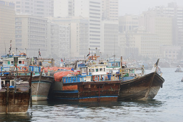 Fototapeta na wymiar Dubai UAE Dhows old wooden sailing vessels are docked along the Deira side of Dubai Creek.