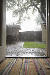 View of heavy rains in backyard through open house door
