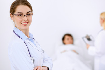 Female doctor smiling on the background with patient and his doctor