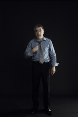 Disappointed businessman pointing finger at himself isolated over black background