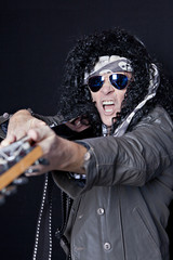 Senior male playing electric guitar over black background