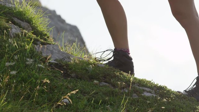 CLOSE UP: Unrecognizable female tourist in hiking shoes going uphill on trail