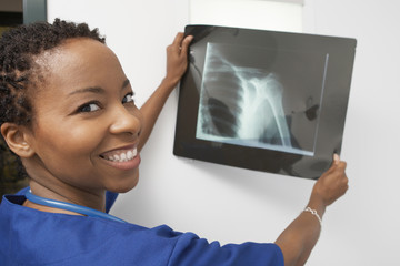 Portrait of a happy doctor holding x-ray report in the clinic